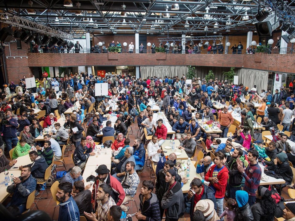 Grosse Halle mit hunderten von Flüchtlingen. 