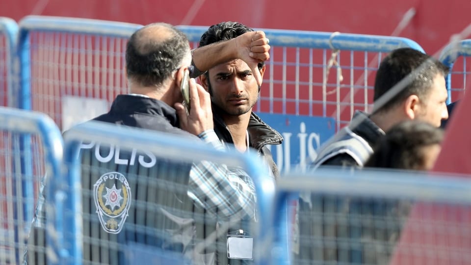 Die türkische Polizei nimmt einen illegal auf Griechenland gereisten Migrant in Empfang, der in die Kamera schaut und den Daumen senkt.
