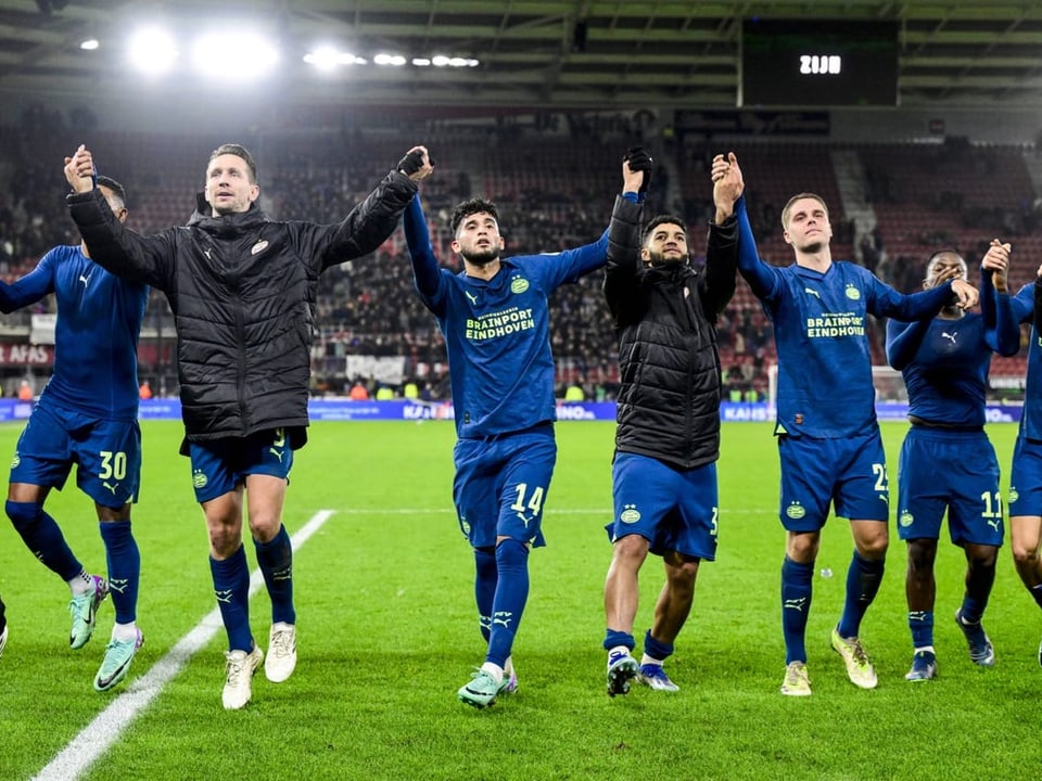 PSV-Spieler halten sich an den Händen und freuen sich mit den Fans