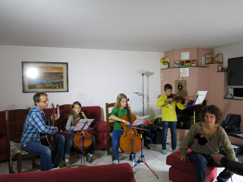 Die Familie musiziert im Wohnzimmer.