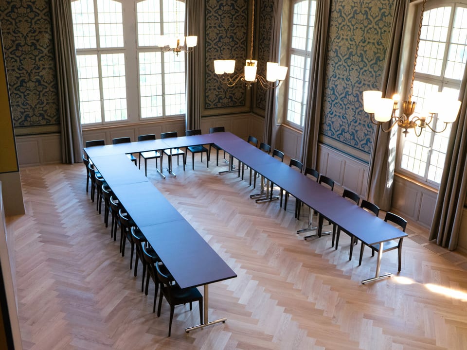 Grosser Raum mit grossem, in U-Form hingestelltem Tisch, Parkettboden
