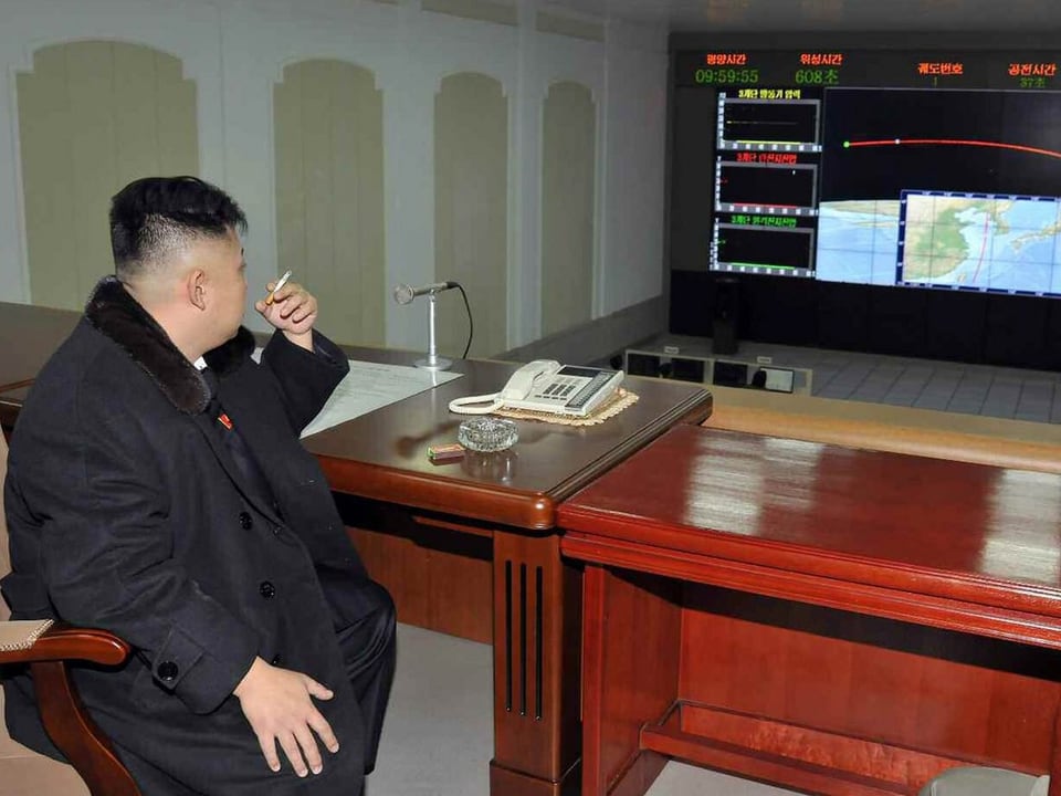 Kim Jong Un mit Zigarette vor einem Monitor.