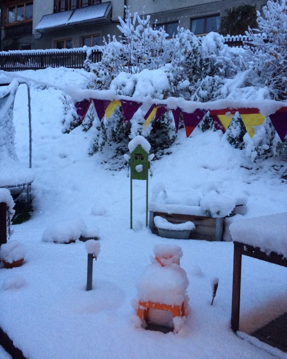 Im Garten liegt eine geschlossene Schneedecke. Die Kinderspielsachen müssen wohl ausgegraben werden.
