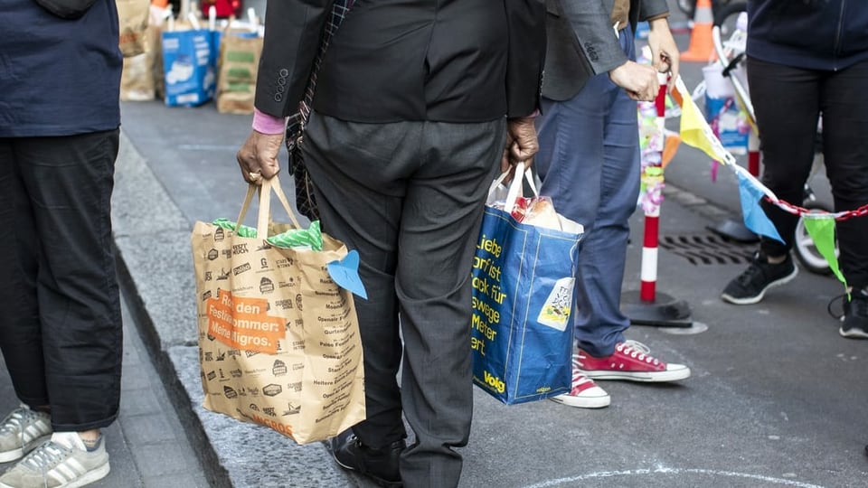 Mann mit zwei Taschen voll Lebensmitteln.