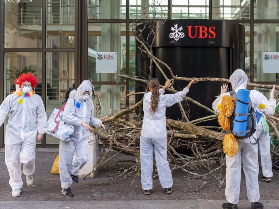 Aktivisten und Baumstämme vor dem UBS-Eingang