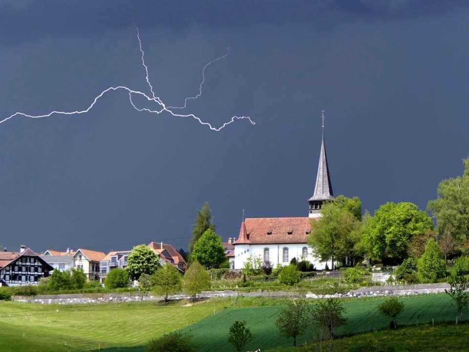 Sonne dunkle Wolken und Gewitter über dem Dorf.