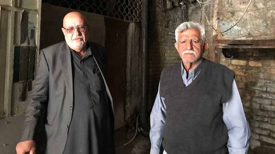 Abu Ali und Abu Ziad stehen nebeneinander, sind adrett gekleidet.. Es sind alte Männer, Ziad trägt ein weisser Schnauz.