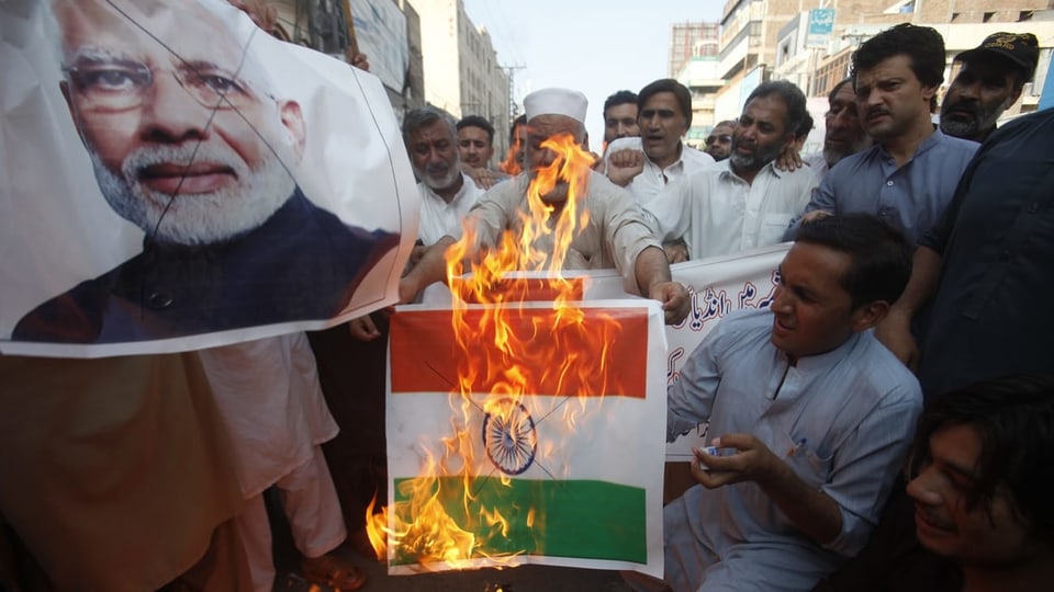 Menschen verbrennen Indienflagge.