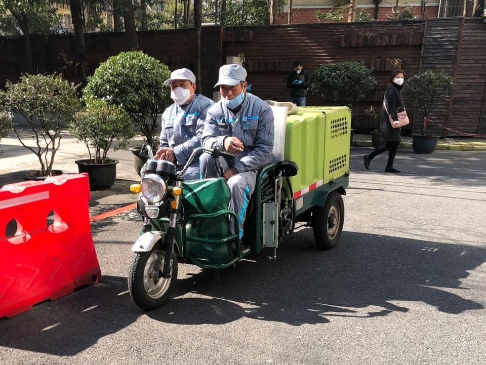 Zwei Männer auf einem motorisierten Liefer-Dreirad