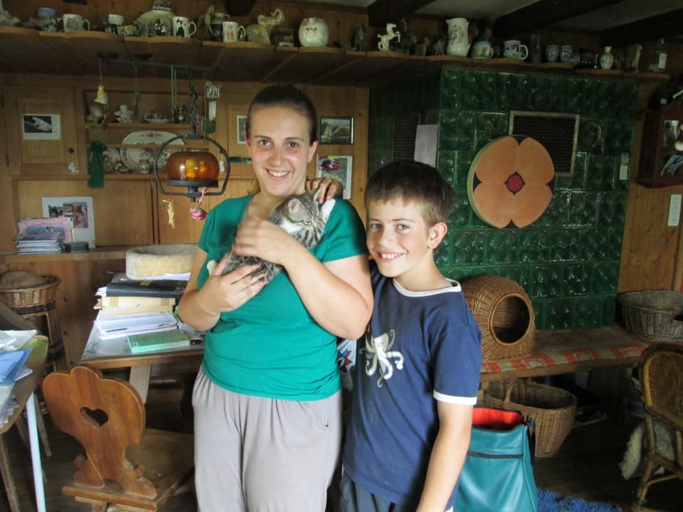 Die Tierheim-Helferin mit einer jungen Katze auf dem Arm, daneben ihr Sohn