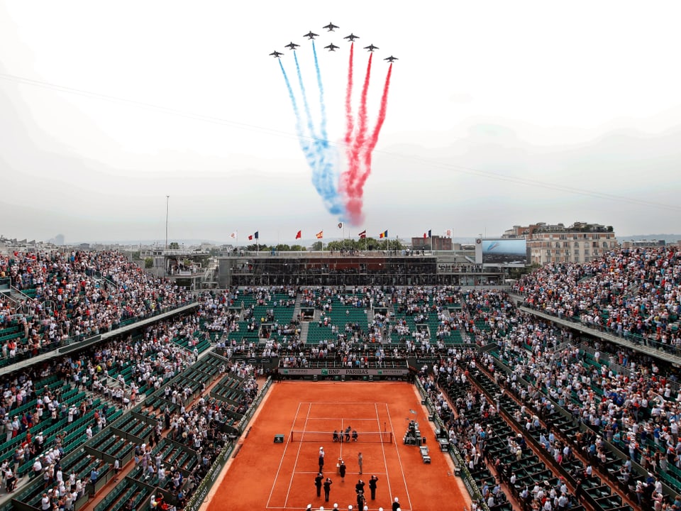 Flugzeuge fliegen über das Tennisstadion in Paris.