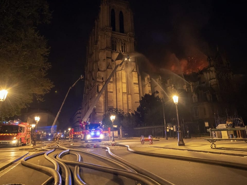 Feuerwehrautos stehen vor der Notre-Dame.