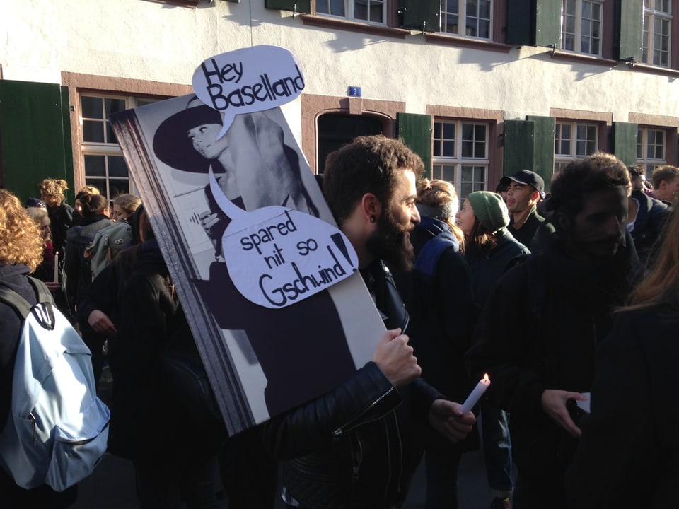 Student hält Schild in die Luft. 