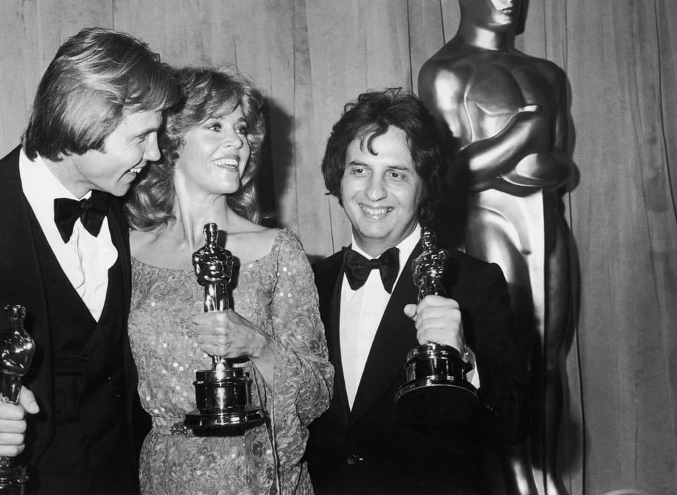 Zwei Männer und eine Frau halten die Oscar-Statue 