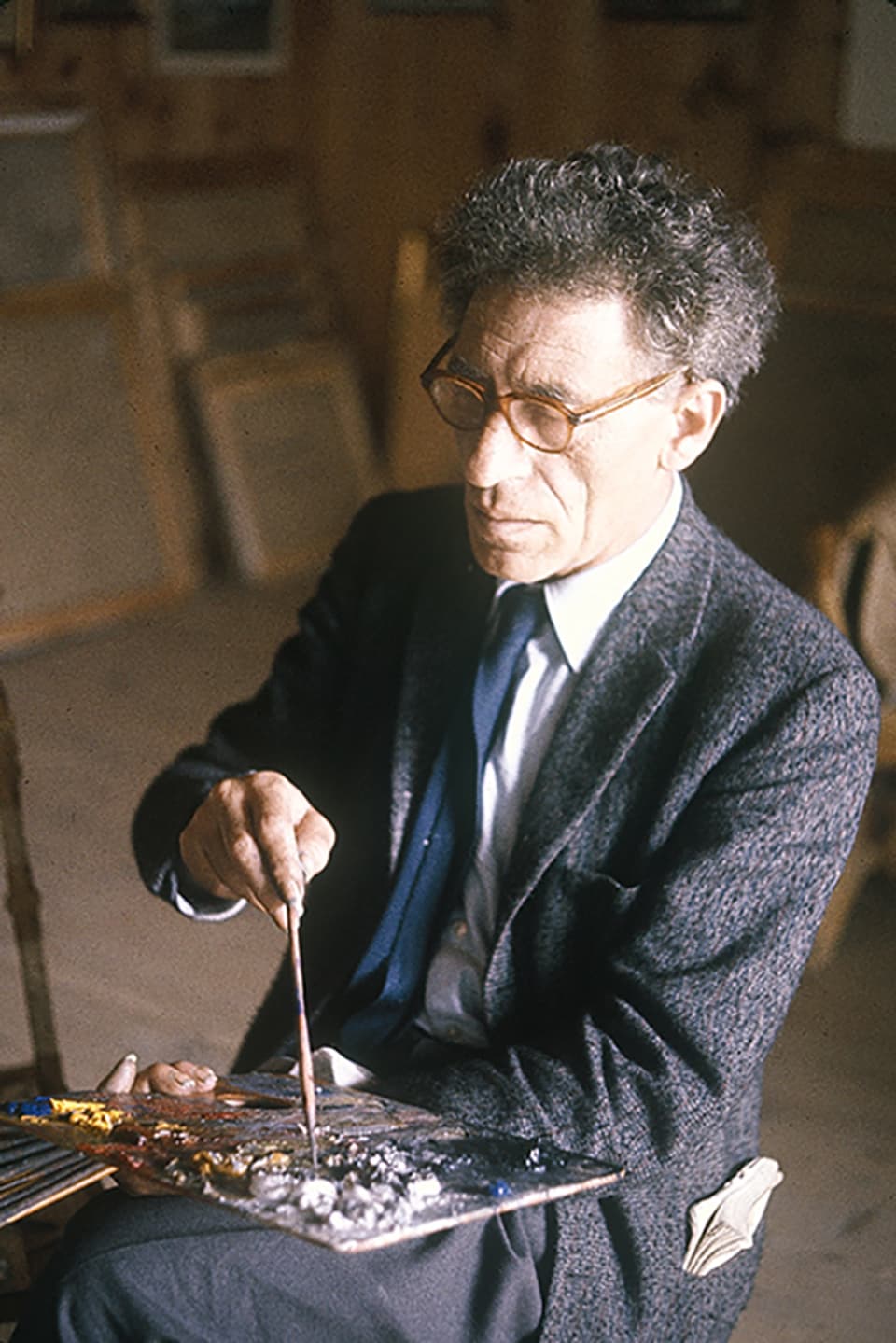 Porträt Alberto Giacometti mit einer Palette auf dem Schoss. 