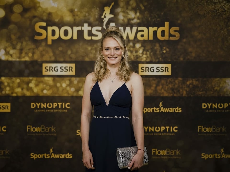 Amy Baserga trägt bei den Sports Awards in der linken Hand eine Handtasche.