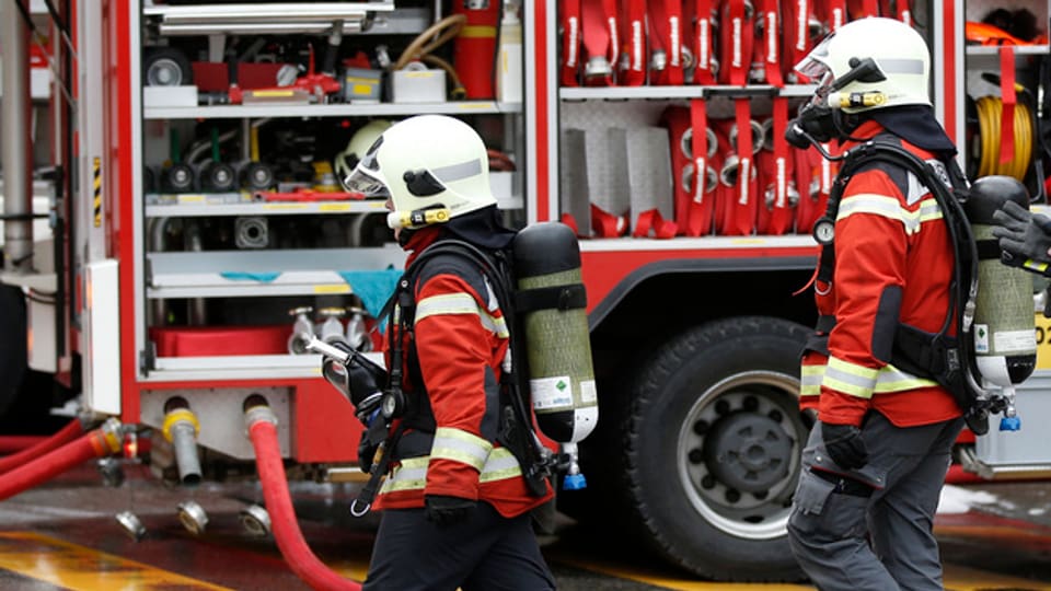 Atemschutz-Feuerwehrleute vor einem Fahrzeug