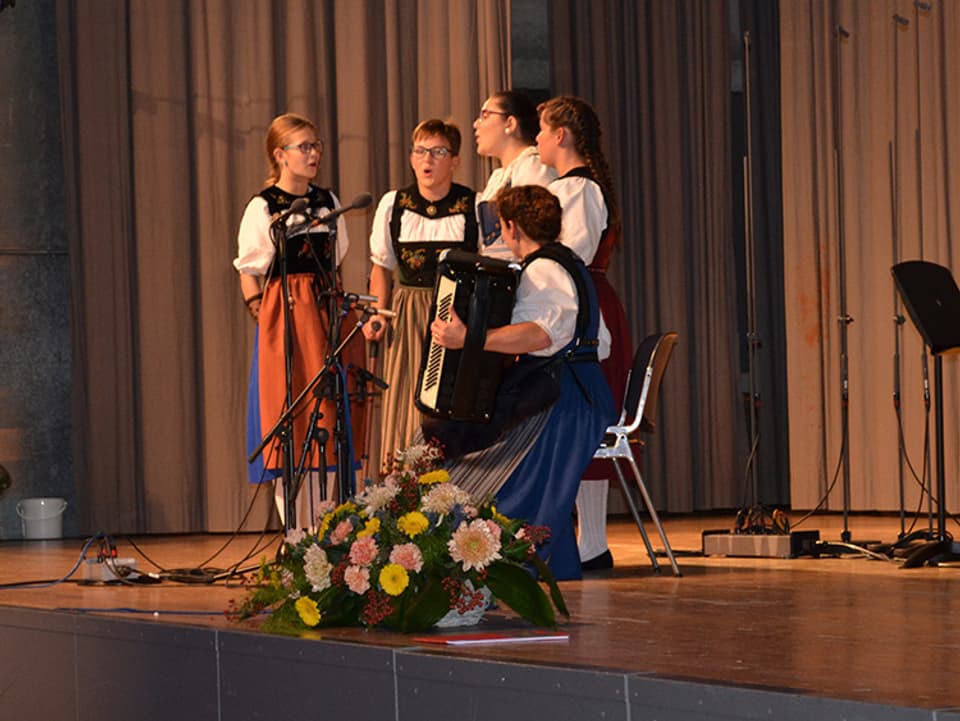 Vier junge Jodlerinnen werden von einer Akkordeonistin begleitet.