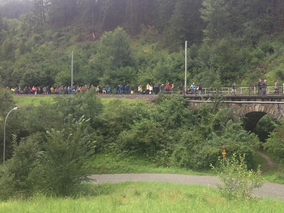 Menschen laufen entlang des Bahntrassees.