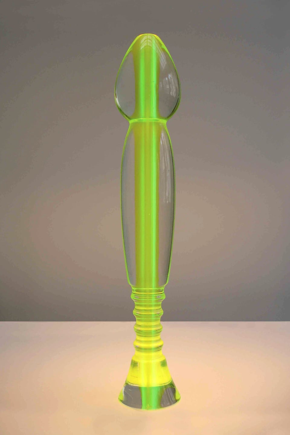 Eine stehende, lange Plastikform mit leuchtend grüner Füllung.