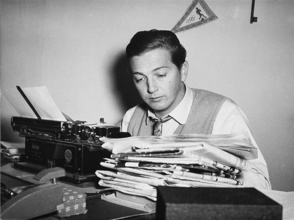Sepp Renggli 1953 mit Bergen von Zeitungen und einer mechanischen Schreibmaschine im Radiostudio Zürich.