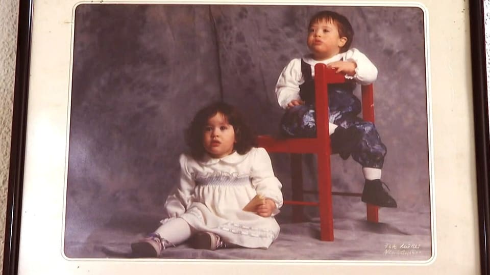 Die Zwillinge, als sie noch Kinder waren: Virginie sitzt am Boden und Samuel hinter ihr auf einem roten Holzstuhl.