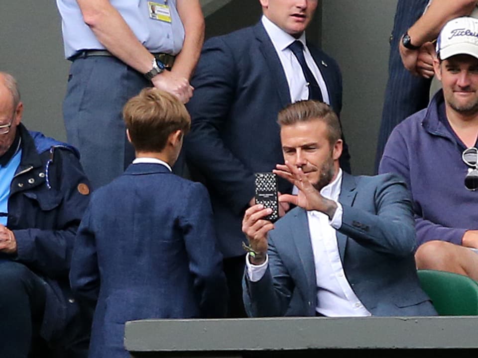 David Beckham macht mit seinem Handy ein Foto von Romeo.