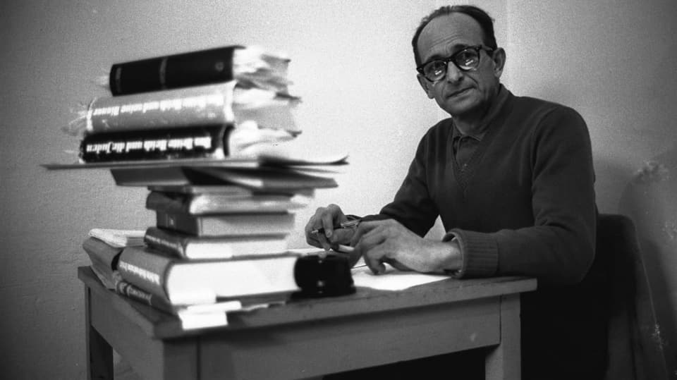 Adolf Eichmann hinter einem Stapel Bücher.