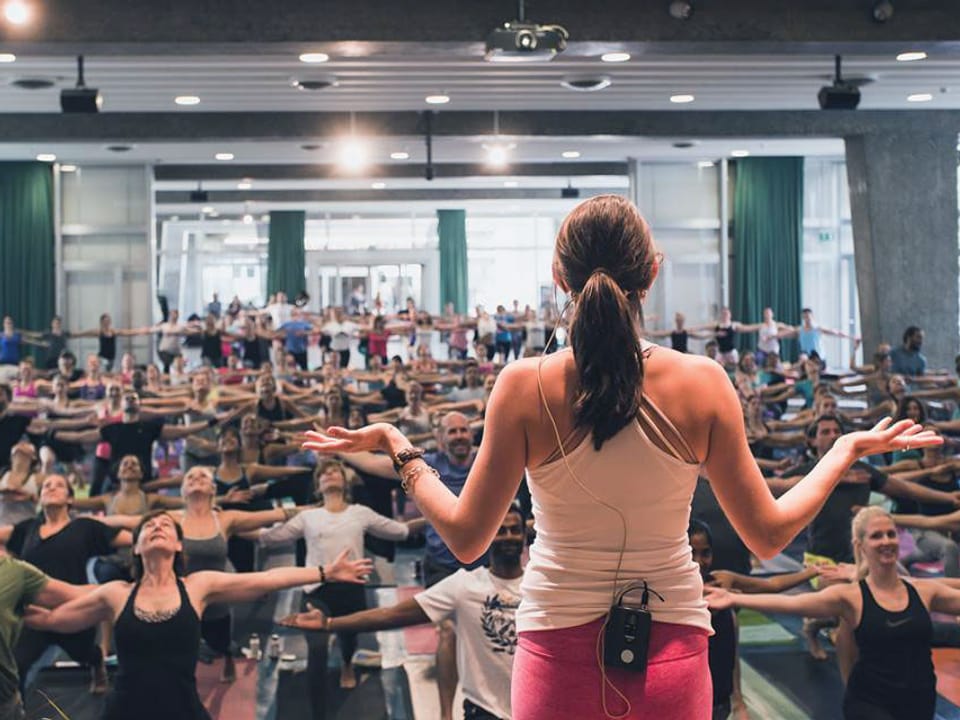 Mirjam Haymann unterrichtet Yoga: Blick über ihre Schulter in die Klasse.
