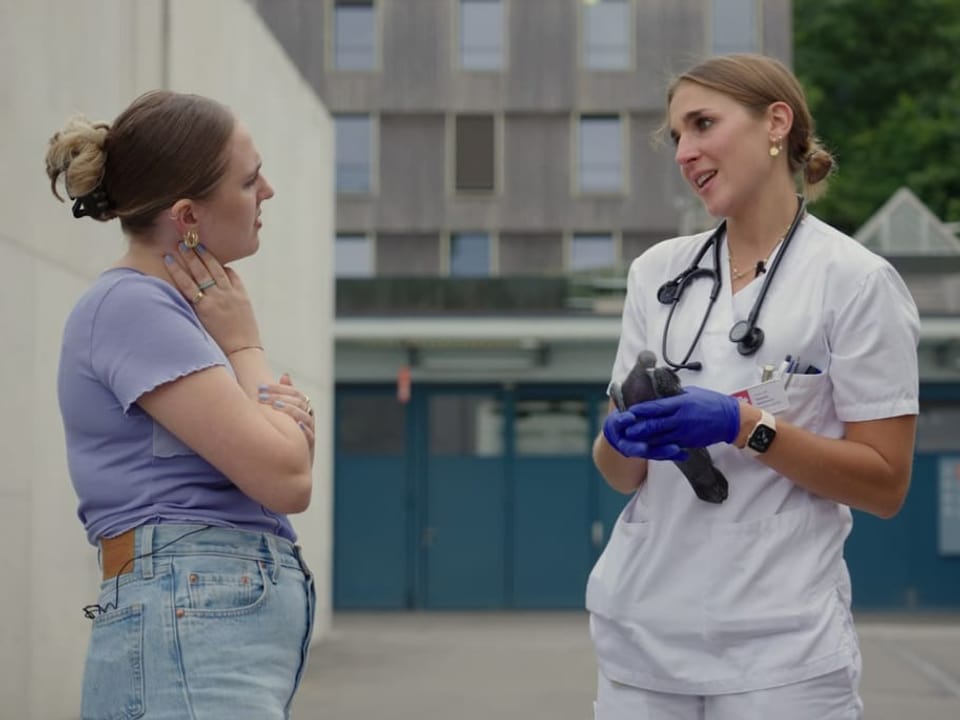 Host Amila unterhält sich mit einer Tierärztin, die eine verletze Taube in der Hand hält.