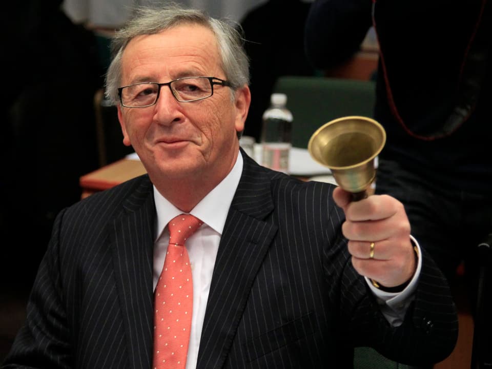 Juncker klingelt lächelnd mit einer Glocke.