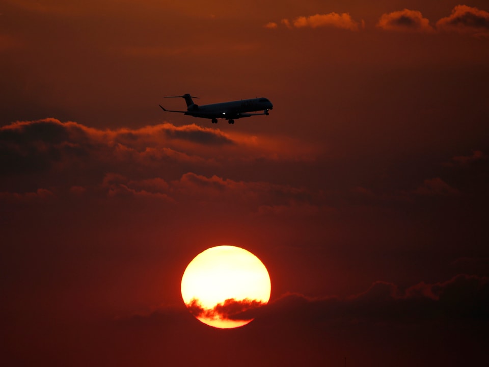 Eine Lufthansa-Maschine vor der untergehenden Sonne 