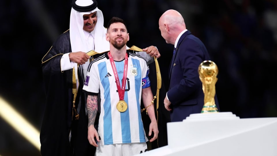 Der Emir von Katar legt Lionel Messi ein Bischd, ein traditionelles katarisches Gewand aus schwarzer Seide über.