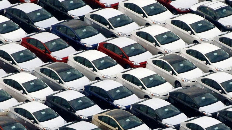 Viele Toyotas auf einem Parkplatz.