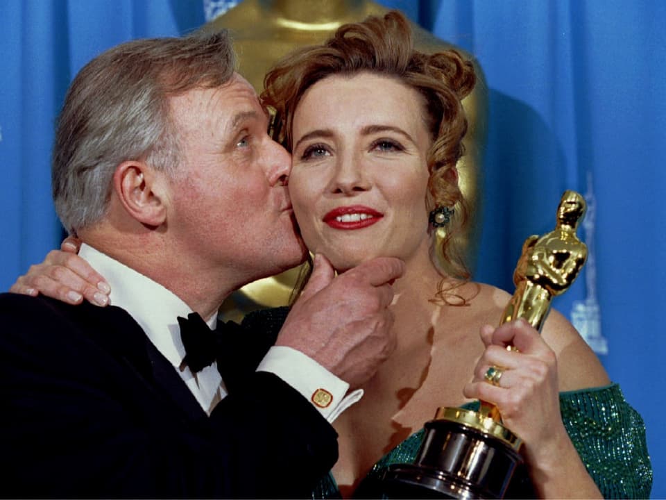 Anthony Hopkins (links) küsst Emma Thompson auf die Wange, die eine Oscartrophäe in der Hand hält