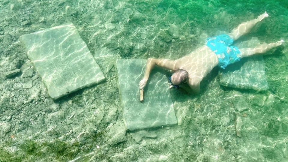 Mann unter Wasser schrubbt einen Stein