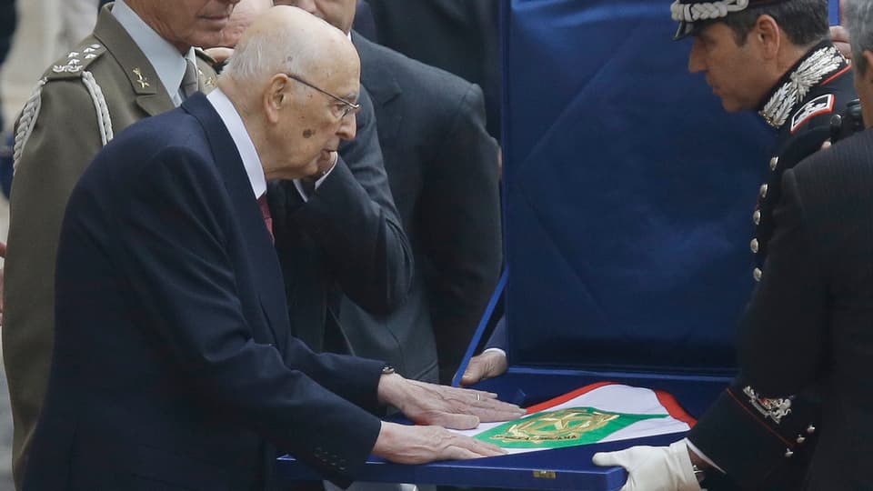 Giorgio Napolitano streicht über die präsidiale Flagge, bevor er den Quirinalspalast verlässt.