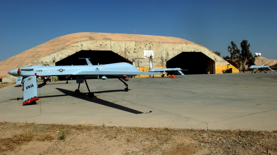 Drohne vor einem Hangar.