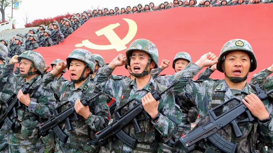 Mitglieder der Kommunistischen Partei Chinas (KPC) legen vor der Parteifahne den Eid auf den Beitritt zur Partei ab.