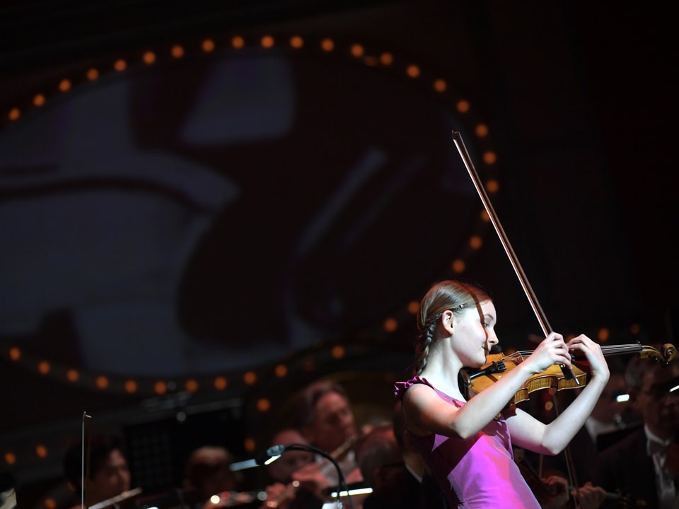 Ein Mädchen mit der Geige auf einer Bühne.