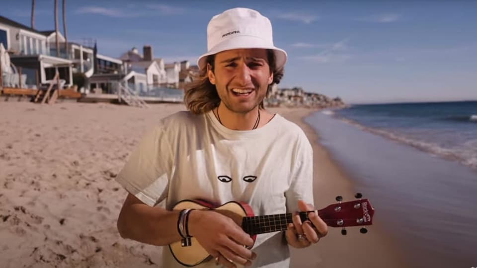 Pat Burgener mit Ukulele am Strand singend