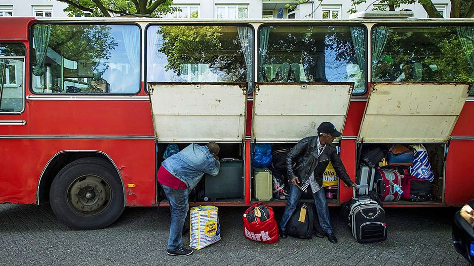 Asylbewerber vor Bus. 
