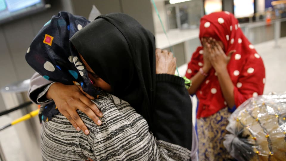 Muslima umarmen sich verzweifelt im Flughafen