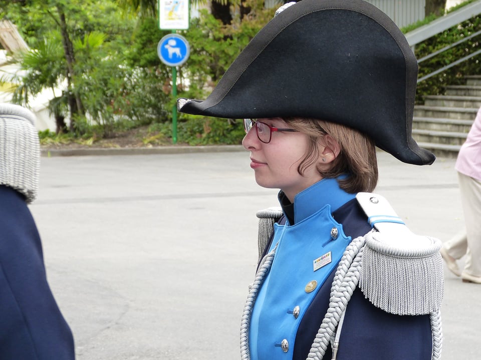 Eine Frau in blauer Uniform mit einem dreieckigen Hut.