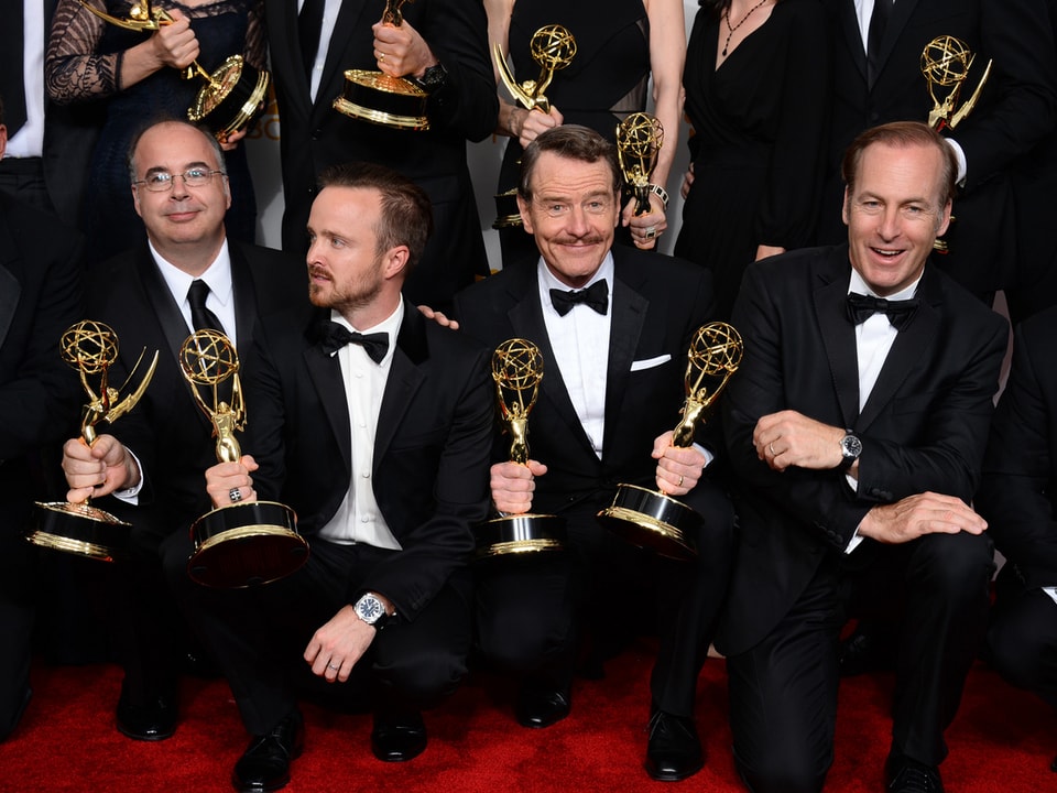 Vier Männer halten einen Emmy in die Kamera