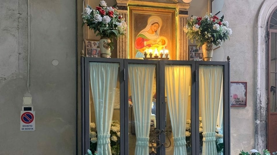 Altar mit Heiligenbild und Fotos