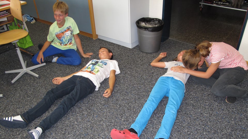 Kinder üben zusammen die Seitenlagerung bei Bewusstlosigkeit.