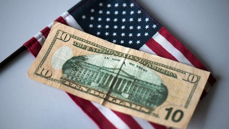 Ein US-Flagge und ein 10-Dolalr-Schein.