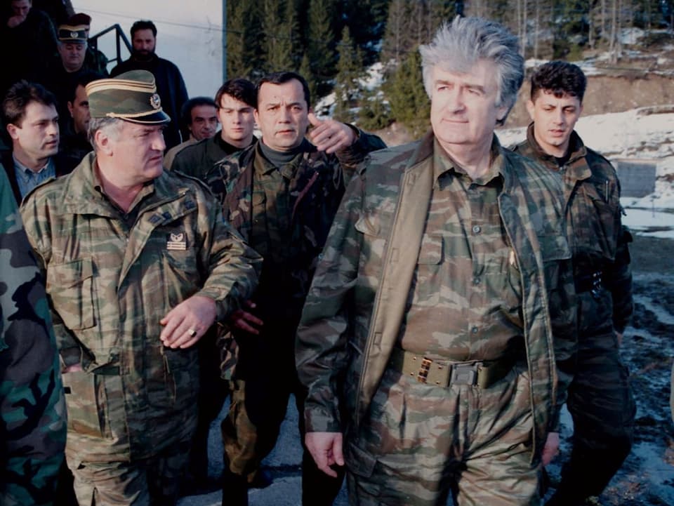 Karadzic und Mladic in Militärkleidung auf einem Landweg. 