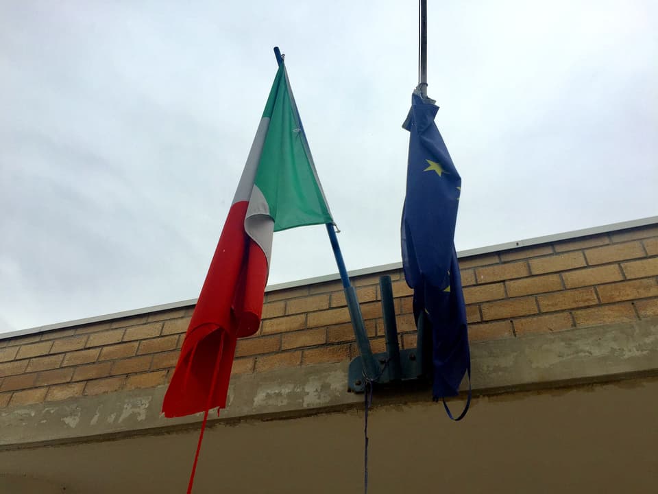 Italiens und Europas Flaggen über dem Eingang einer römischen Schule.